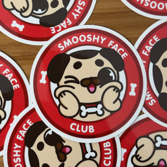 Stickers with cartoon dog face design and 'Smooshy Face Club' text on a wooden surface.